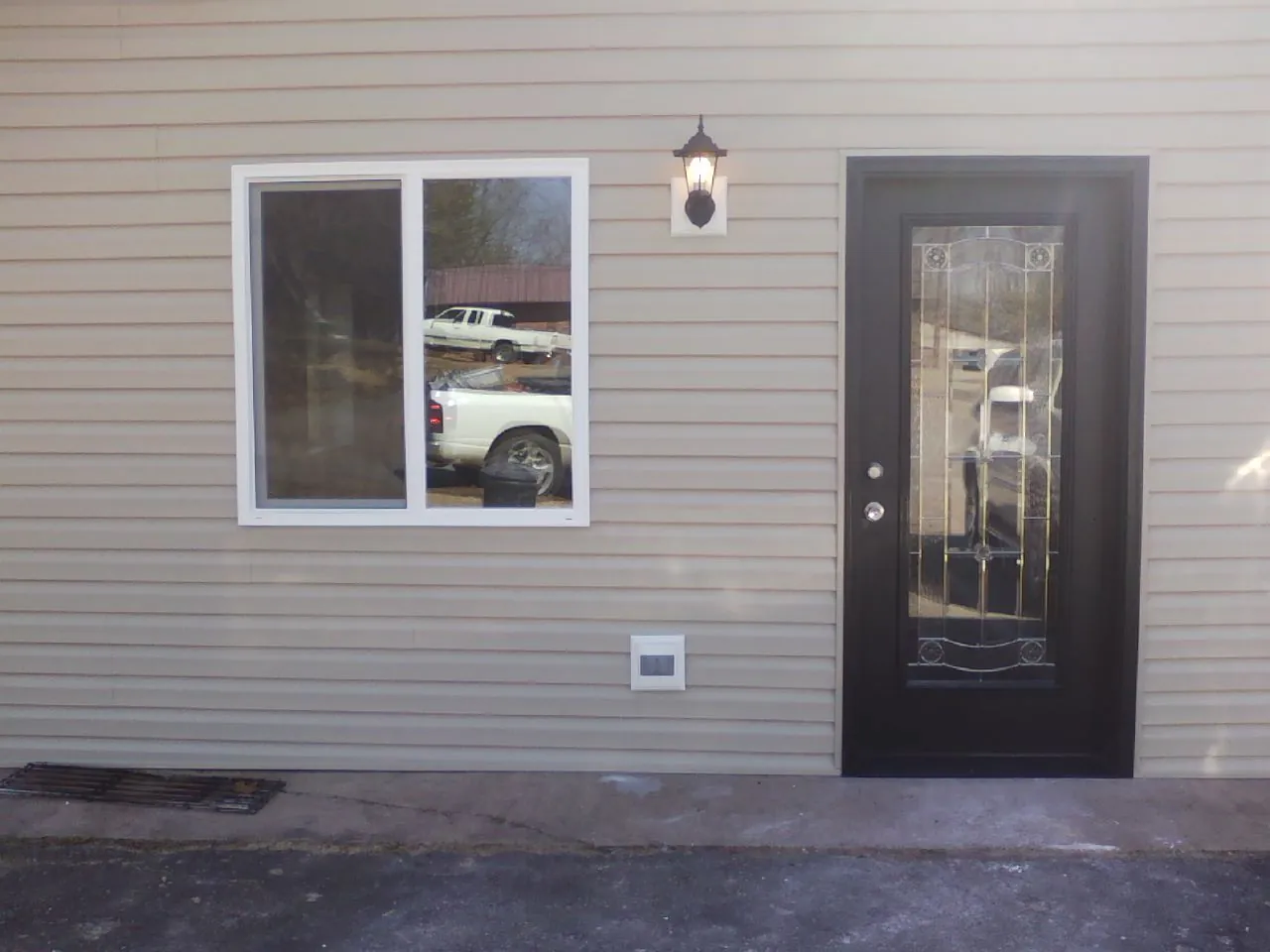 New siding, window and entry door on the side of an addition in Moline